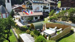 an aerial view of a house with flags in a yard at Hotel Piedibosco in Moena