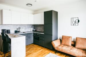 a kitchen with green cabinets and a counter and chairs at Love Suite in Mörbisch am See