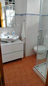 a white bathroom with a sink and a toilet at La casa de Yeico in Puebla de Lillo