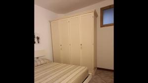a bedroom with a bed and a white cabinet at Appartamento - Villaggio Terrata- Golfo Aranci in Marinella