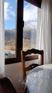una mesa y una silla frente a una ventana en La casa de Yeico, en Puebla de Lillo