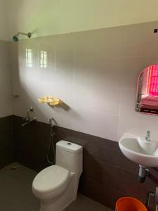 a bathroom with a white toilet and a sink at The Grand White House - Entire Villa in Thekkady