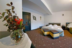 a hotel room with two beds and a vase of flowers at Pensiunea Mugur De Fluier in Vama