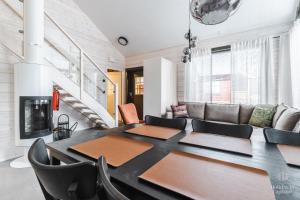 a dining room with a table and a couch at Holiday in Lapland - Sointuilevi Exclusive A60 in Levi