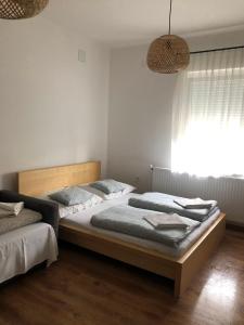 two twin beds in a bedroom with a window at Borbély apartman in Nagykanizsa