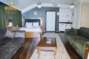 Sala de estar con cama, sofá y mesa en Rixson Otel en Avcılar