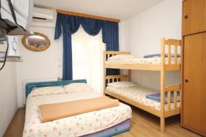 a bedroom with two bunk beds and a window at Apartments by the sea Kastel Kambelovac, Kastela - 8627 in Kaštela