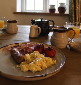 a plate of breakfast food on a wooden table at Crina Bottom - Offgrid Mountain Escape in the Yorkshire Dales National Park in Ingleton