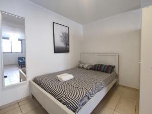 een bed in een witte kamer met een spiegel bij Willy Brandt Studios - Best Location in Tel Aviv
