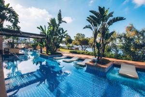 una piscina con tumbonas y palmeras en Iberostar Selection Jardín del Sol Suites - Adults Only en Santa Ponsa