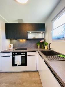 a kitchen with white cabinets and a stove and a sink at Ferienhaus Walcher in Sankt Martin am Grimming