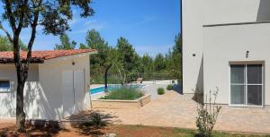 a white house with a swimming pool in a yard at Villa Mare in Ližnjan