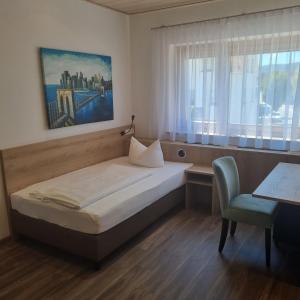 Schlafzimmer mit einem Bett, einem Schreibtisch und einem Stuhl in der Unterkunft Hotel & Restaurant Krone in Geislingen an der Steige