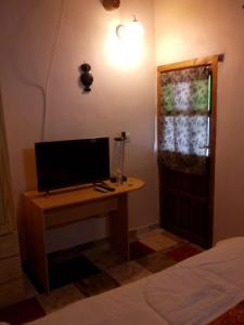 a desk with a computer on it in a bedroom at Hotel de Campo Oeste Paraíso in La Ciénaga