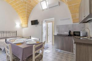 een keuken en een eetkamer met een tafel en stoelen bij Casa Emi by BarbarHouse in Veglie