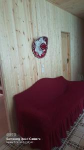 a bedroom with a bed with a red blanket on the wall at Gomi Riverside in Gomi