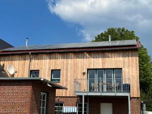 une maison dotée d'un toit solaire et d'un balcon. dans l'établissement Ferienwohnung Schwalbennest, à Bünsdorf