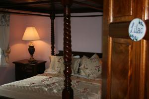 a bedroom with a canopy bed and a lamp at Avarest Bunratty B&B in Bunratty