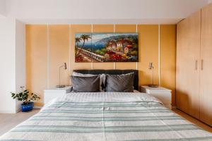 um quarto com uma cama grande e uma pintura na parede em Sunsets at the Palace em Bucareste