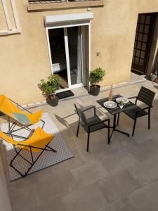a patio with two chairs and a table and chairs at Studio pour 2 avec terrasse au pied de la Cité : ma pierre à l’édifice in Carcassonne