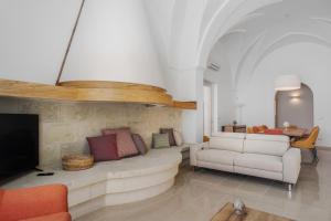- un salon avec un canapé et une télévision dans l'établissement VILLA ROSA MEDITERRANEA, à Marina di Pescoluse