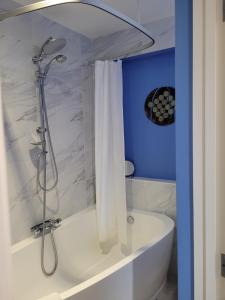 a bathroom with a tub and a shower with a shower curtain at Milton Court in Sittingbourne