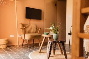 a living room with a chair and a table at B&B Maison Lize in Lievegem