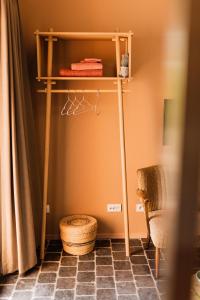 une étagère dans une pièce avec une chaise et un panier dans l'établissement B&B Maison Lize, à Lievegem
