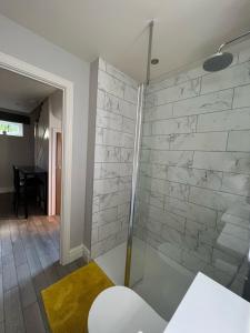 uma cabina de duche em vidro na casa de banho com uma mesa em The Annexe, Farnborough em Farnborough