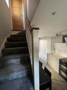 eine Treppe, die zu einer Küche in einem Haus führt in der Unterkunft The Annexe, Farnborough in Farnborough