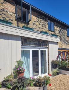 uma casa com uma porta de vidro deslizante e vasos de plantas em Milton Court em Sittingbourne