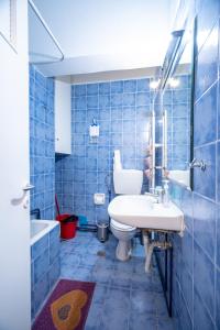 bagno piastrellato blu con lavandino e servizi igienici di Independent Apartment at Lykavitos 1 bed 2 pers ad Atene