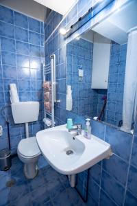 bagno piastrellato blu con lavandino e servizi igienici di Independent Apartment at Lykavitos 1 bed 2 pers ad Atene