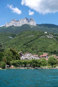 un pueblo a orillas de un lago con montañas en Hôtel Beau Site Talloires B SPA en Talloires
