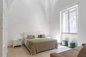 a white bedroom with a bed and a window at VILLA ROSA MEDITERRANEA in Marina di Pescoluse