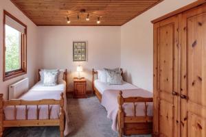 a bedroom with two beds and a wooden ceiling at The Gamekeeper's Inn in Skipton