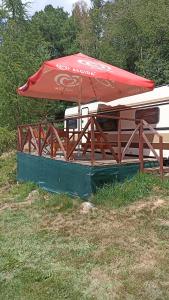 a red umbrella sitting on top of a table at Karavan 1 v areálu Koupaliště Bystré v Orlických horách in Bystré