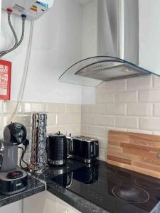 a kitchen with a black counter top with a stove at Fully equipped 2 bed flat on Old Compton St! in London