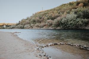 a river with a rocky shoreline and a mountain at CASADORIO in Constância