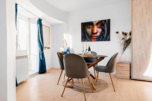 a dining room with a table and a painting on the wall at Sunsets at the Palace in Bucharest