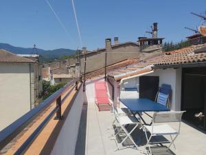 un patio con sillas y una mesa en el techo en Superbe appartement au cœur des cévennes, en Avèze