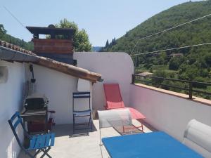 Un patio con sillas y una mesa en el balcón. en Superbe appartement au cœur des cévennes, en Avèze