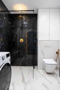 La salle de bains est pourvue d'une douche et de toilettes. dans l'établissement HORIZON HEVENIA Rewal Apartament z dużym tarasem i widokiem na morze, à Rewal