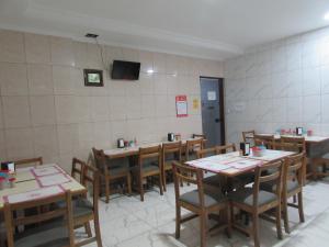 comedor con mesas y sillas y TV en Teodoro Palace Hotel a 5 minutos do Brás e Bom Retiro, en São Paulo