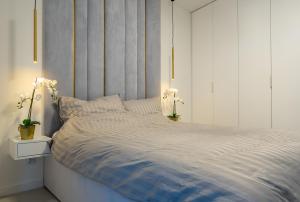 sypialnia z dużym łóżkiem z białym zagłówkiem w obiekcie HORIZON HEVENIA Rewal Apartament z dużym tarasem i widokiem na morze w Rewalu +27 zdjęć