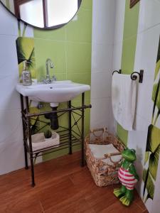 ein Badezimmer mit einem Waschbecken und einer grün-weißen Wand in der Unterkunft Apartamento La Villa in Valverde + 5 Fotos