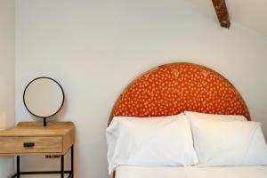 a bed with an orange headboard and a mirror at CoalShed Lofts - Groups -Exclusive Use in Bristol