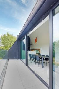 a glass extension of a house with a dining table at Apartment L'O Reine in Sint-Pieters-Leeuw