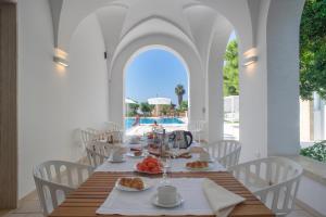 una sala da pranzo con tavolo e cibo di VILLA ROSA MEDITERRANEA a Marina di Pescoluse