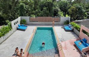 two women are sitting in a swimming pool at Comet Hotel Surat Thani in Surat Thani